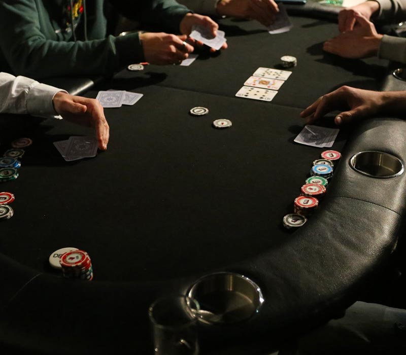 Table de poker avec jetons et mains des joueurs